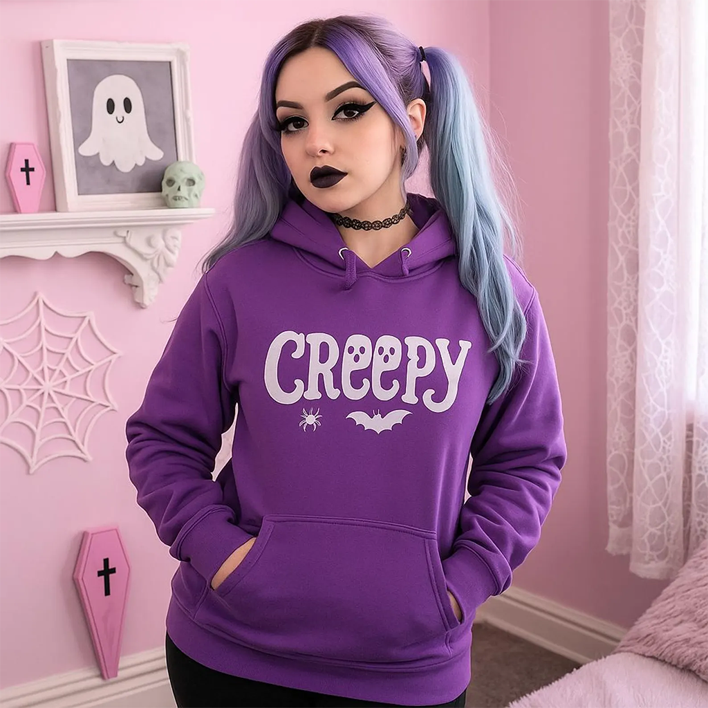 Person wearing a purple hoodie with 'Creepy' text in a room with pink walls and Halloween decorations.